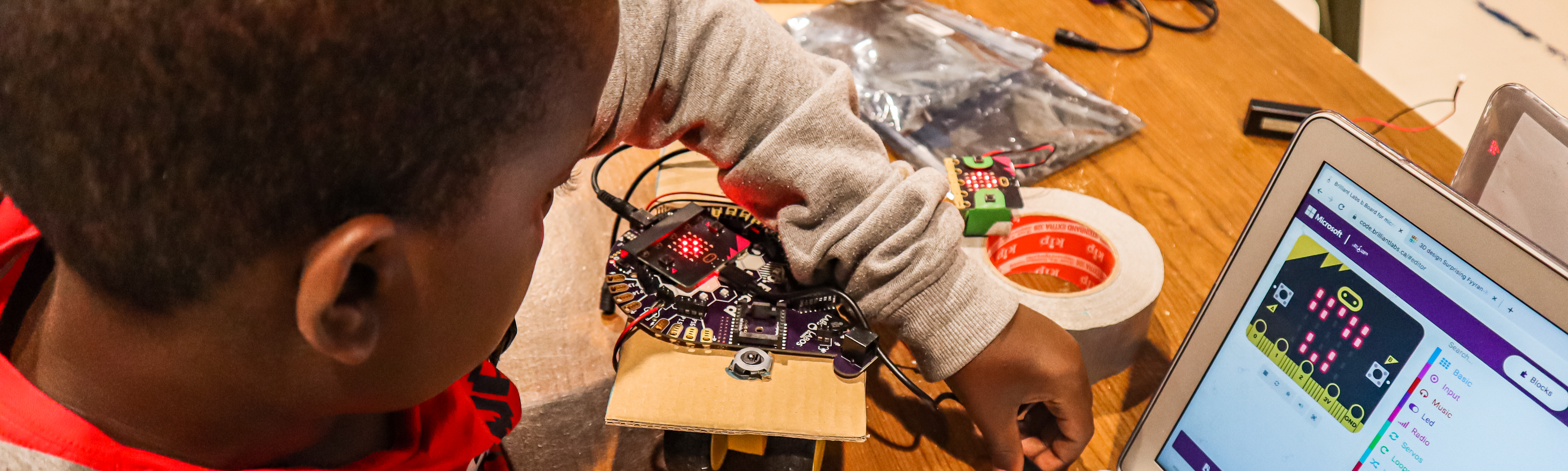 Student plugging a b.Board into a laptop